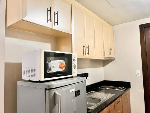 a kitchen with a microwave on top of a refrigerator at Newport Hotel near NAIA Manila Airport Terminal Pasay in Manila