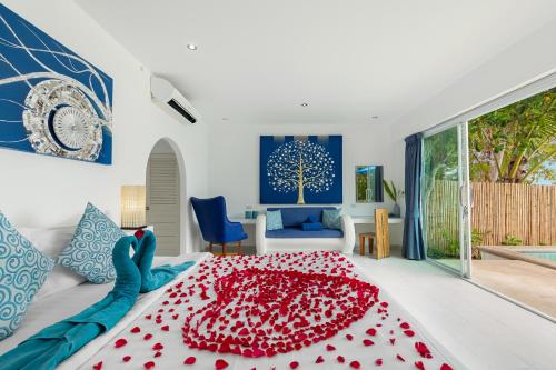 een slaapkamer met een groot bed en een rode deken bij La Perle Resort Koh Samui in Mae Nam