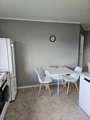 een keuken met een witte tafel en 2 stoelen bij Ridgetop Farmstay in Oruanui