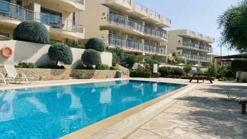 a swimming pool in front of a building at Lagada Resort in Makry Gialos