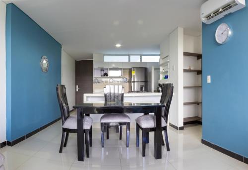 a dining room with a black table and chairs at El Refugio Ricaurte - Piscina Renovada in Ricaurte
