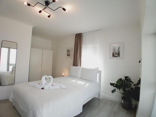 a bedroom with a white bed with a swan on it at PRIMA APARTMENTS in Satu Mare