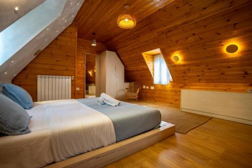 ein Schlafzimmer mit einem großen Bett in einem Holzhaus in der Unterkunft Hotel Restaurant Alpet Theth in Theth
