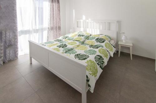 a white bed with a green and yellow comforter at Orscholz in Orscholz