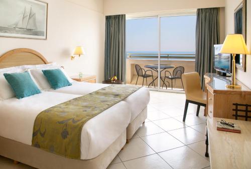 a hotel room with a bed and a view of the ocean at Atlantica Miramare Beach in Limassol