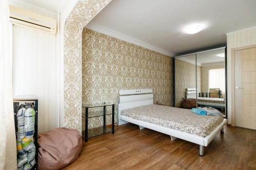 un dormitorio con una cama y un espejo en Kvartirkoff na Obolonskiy prospekt 31, en Kiev