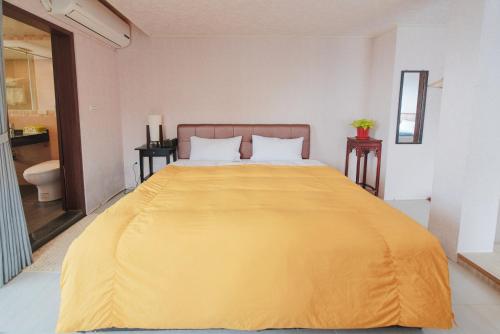 a bedroom with a large yellow bed with two tables at Arabian Nights in Jiufen in Jiufen