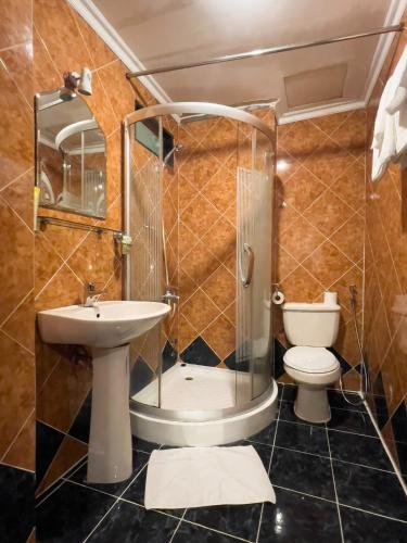 a bathroom with a shower and a toilet at Little Brick Saigon Hotel in Ho Chi Minh City