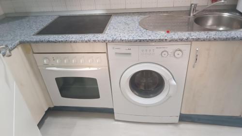 a kitchen with a washing machine and a sink at The Flats in Ávila