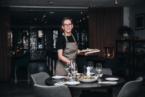 a woman standing next to a table with a plate of food at Clarion Hotel Grand Östersund in Östersund