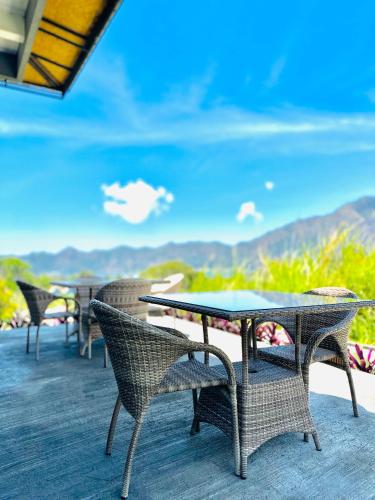 a table and chairs on a deck with a view at Batur Volcano Guesthouse in Kintamani