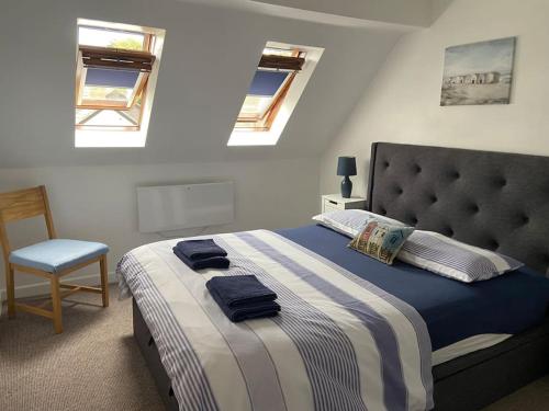 a bedroom with a bed with blue towels on it at Honey Cottage in Totland