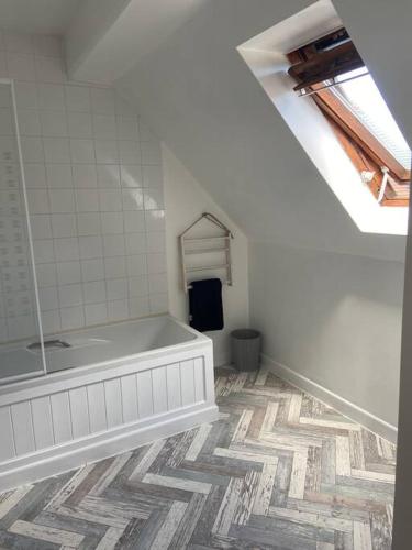 a bathroom with a tub and a tile floor at Honey Cottage in Totland
