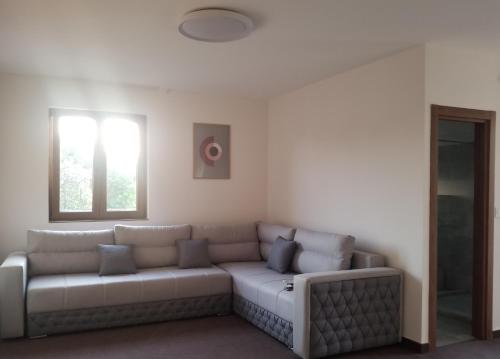 a living room with a couch and a window at Vila Dvor SUBOTICA in Subotica