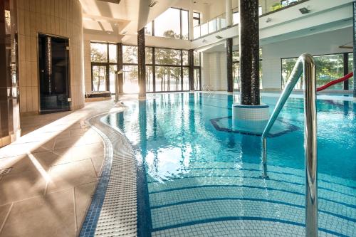 a swimming pool with a slide in a building at Pirat Hotel & SPA-hotel z basenem in Olsztyn