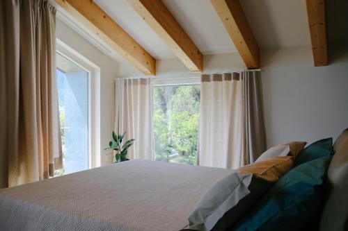 um quarto com uma cama e uma grande janela em La Maison du Renard, villa con giardino e vista sulle montagne em Aosta