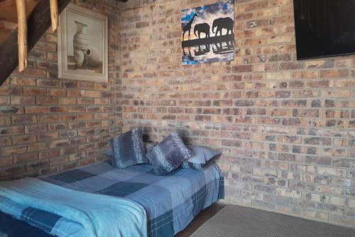 - un mur en briques avec un lit dans une chambre dans l'établissement Bushveld Bliss, à Marloth Park