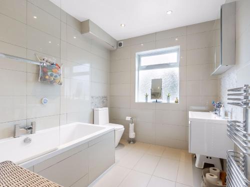 a white bathroom with a tub and a sink at Willow Road Enfield Town Greater London in Enfield