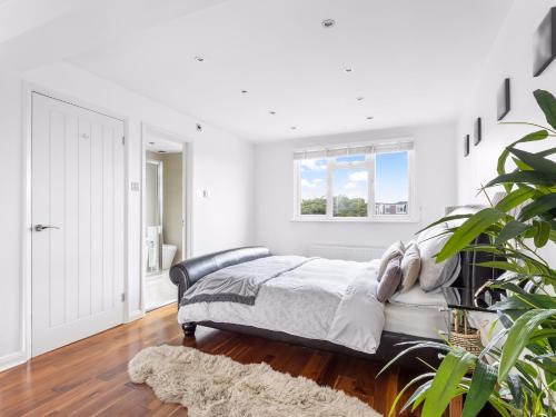 a white bedroom with a bed and a window at Willow Road Enfield Town Greater London in Enfield