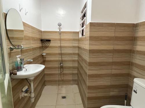a bathroom with a shower and a sink and a toilet at Reinhardshausen Suites and Residences - Cozy Air-conditioned Units in Tuguegarao City