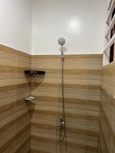 a shower with a shower head in a room at Reinhardshausen Suites and Residences - Cozy Air-conditioned Units in Tuguegarao City