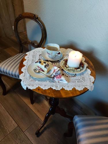 a table with a candle and a cup of tea at Apartamenti Dundaga XXL in Dundaga