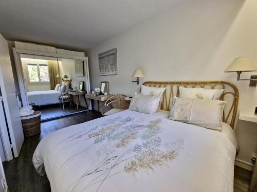 une chambre avec un grand lit avec des draps et des oreillers blancs dans l'établissement Charmant 2 pièces à deux pas de la mer, à Cabourg