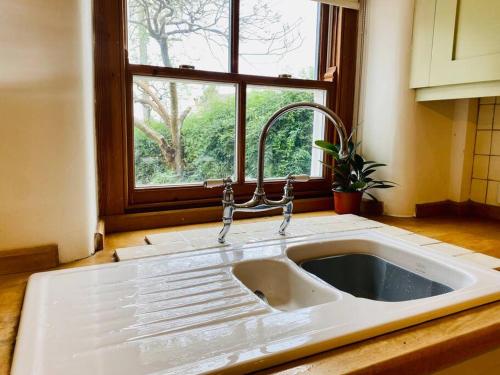 a white sink in a kitchen with a window at Cotswold Home over 4 floors - perfect for Families Friends Contractors in Chipping Norton