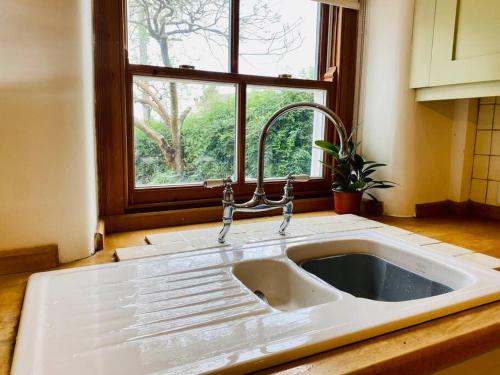 a white sink in a kitchen with a window at Cotswold Home perfect for Families Friends Contractors in Chipping Norton