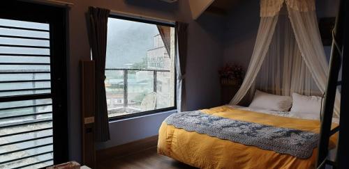 a bedroom with a canopy bed and a large window at Arabian Nights in Jiufen in Jiufen