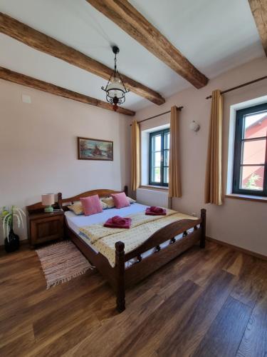 ein Schlafzimmer mit einem großen Bett in einem Zimmer mit Holzböden in der Unterkunft Taverna 1860 Rooms & Apartments in Donja Zelina
