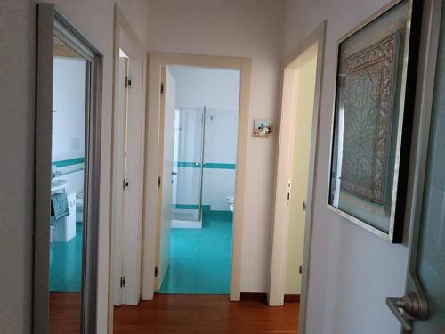 - un couloir avec une salle de bains pourvue d'un lavabo et d'un miroir dans l'établissement Appartamento Casa Verona, à Vérone