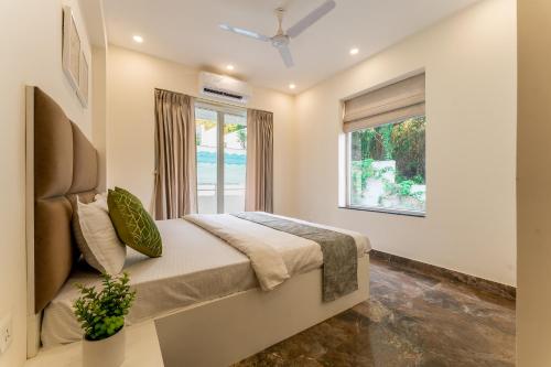 a bedroom with a bed and a window at Lavish Apartments with Swimming Pool near Candolim Beach in Marmagao