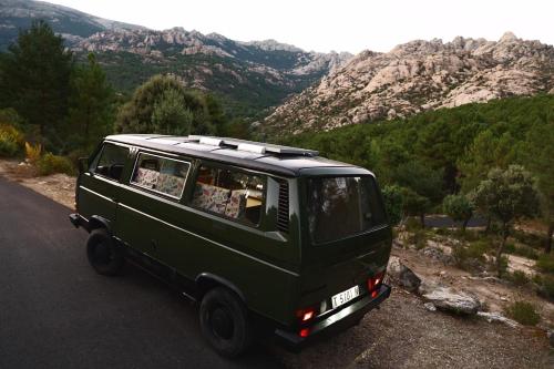 a green van parked on the side of a road at Camper en Guadarrama in Manzanares el Real