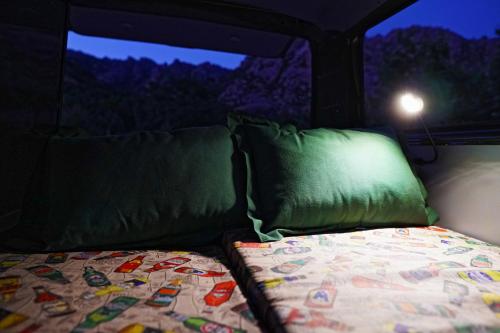 a bed and pillows in the back of a van at Camper en Guadarrama in Manzanares el Real