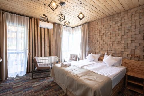 a bedroom with a large bed and a large window at Ego Hotel Буковель in Yablunytsya