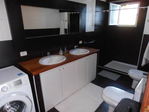 a bathroom with two sinks and a washing machine at Atlantic paradise in Los Realejos