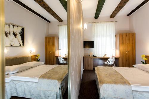 a hotel room with two beds and a desk at Hotel Patio Old Town in Wrocław