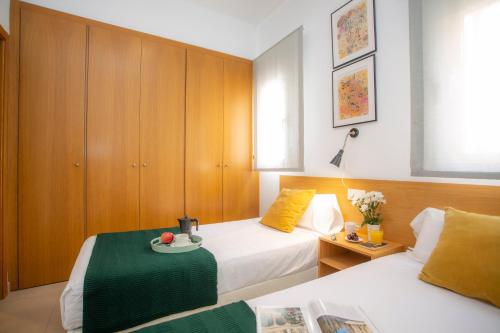 a hotel room with two beds and a table with a plate on it at SingularStays Mar44 in Valencia