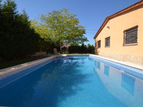 a blue swimming pool next to a building at Villa Brigitte private pool 10 kms LLoret de mar in Maçanet de la Selva