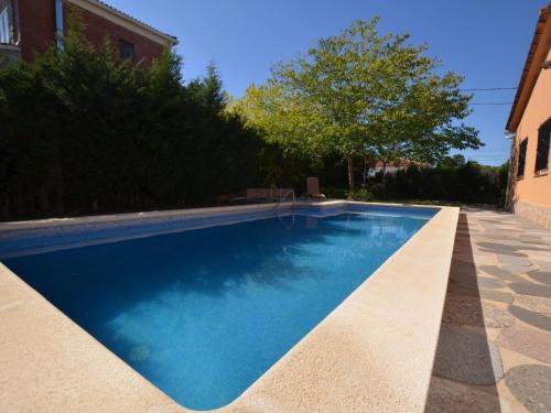 a swimming pool with blue water in a yard at Villa Brigitte private pool 10 kms LLoret de mar in Maçanet de la Selva