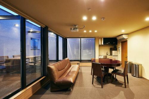 uma sala de estar com um sofá de couro e uma mesa em 634 Condo Shinjuku - Vacation STAY 01902v em Tóquio