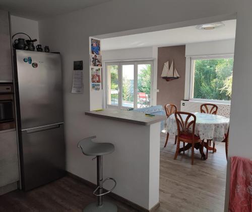uma cozinha com um frigorífico e uma mesa com cadeiras em Villa de plain-pied au calme em Mundolsheim