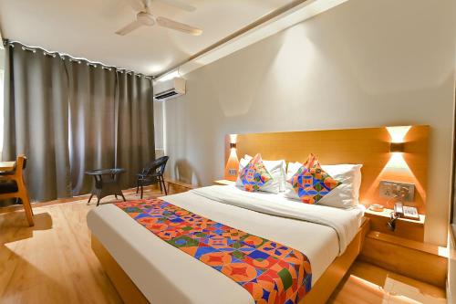 a hotel room with a large bed and a desk at FabHotel Penthouse in Guwahati