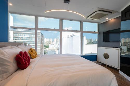 ein Schlafzimmer mit einem weißen Bett mit zwei ausgestopften Tieren in der Unterkunft Tung Nam Lou Art Hotel in Hongkong