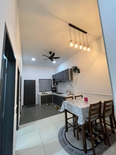 a kitchen and dining room with a table and a ceiling fan at Armaya Pool Villa Klang in Klang