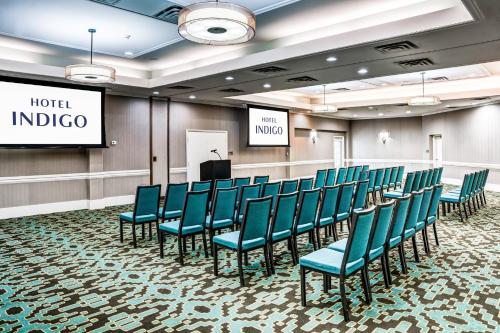 una sala de conferencias con sillas azules y un podio en Hotel Indigo Atlanta Vinings, an IHG Hotel en Atlanta