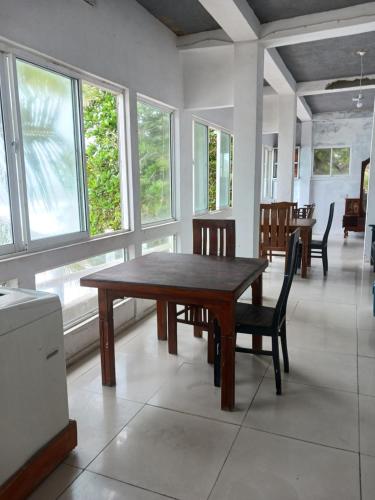 a dining room with a table and chairs and windows at SEASHORE Resort & Villa in Talpe