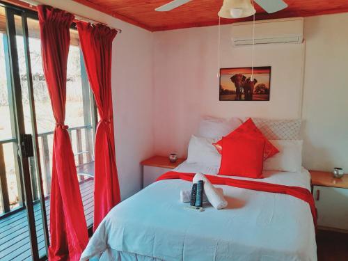 a bedroom with a bed with red curtains at Igula lodge in Mkuze
