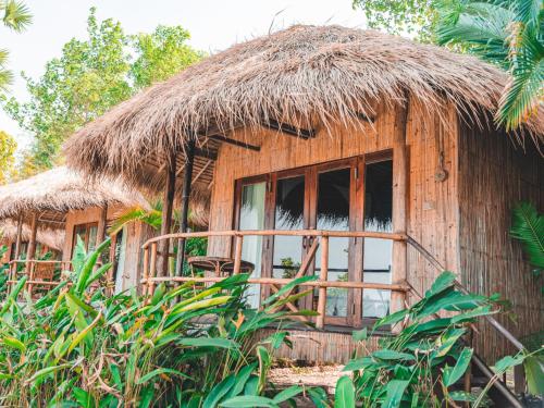 a small hut with a straw roof and a window at Devi Kampot Resort at Phum Kampot in Kampot